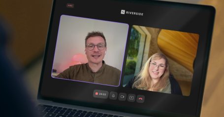 Zwei Personen in einem Videoanruf auf einem Laptop, freundlich lächelnd.